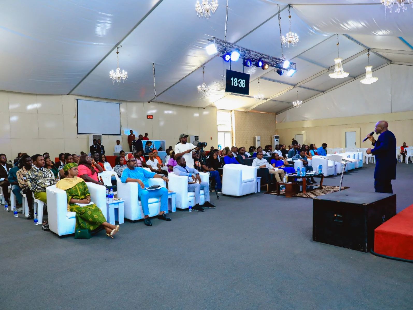 An Eden facilitator conducting a session for a seated audience